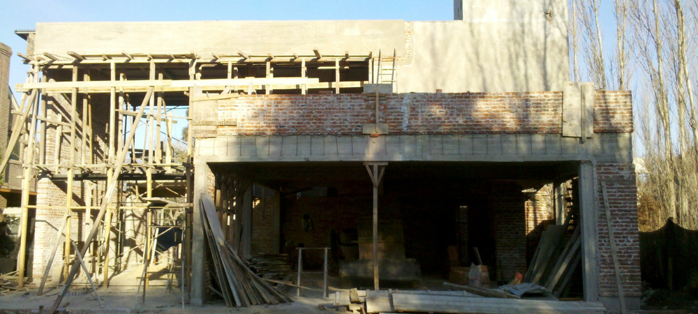 Vivienda de dos plantas en construcción con ladrillo visto y encofrado de madera