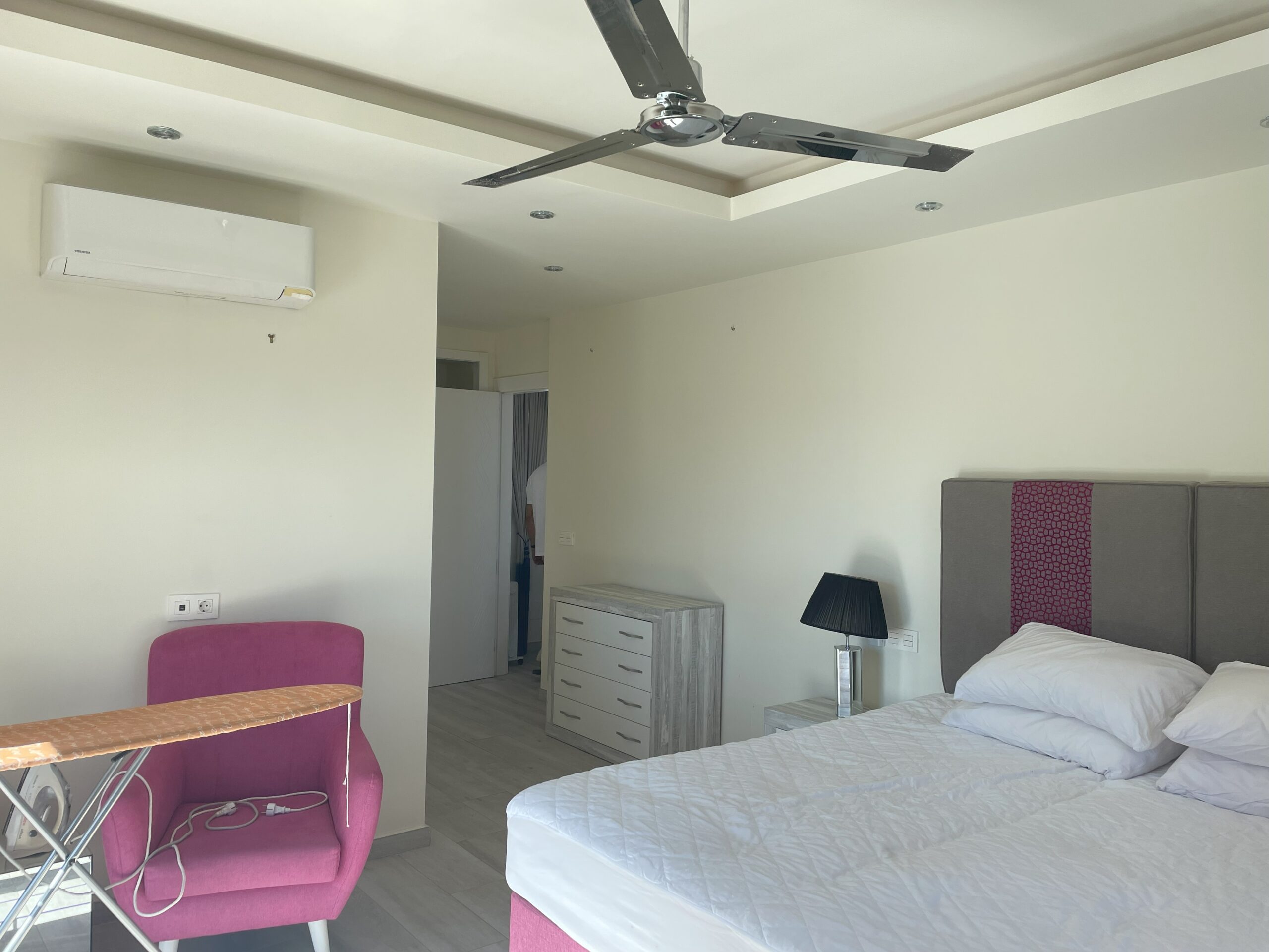 Dormitorio existente con cama doble, cómoda, sillón y ventilador de techo