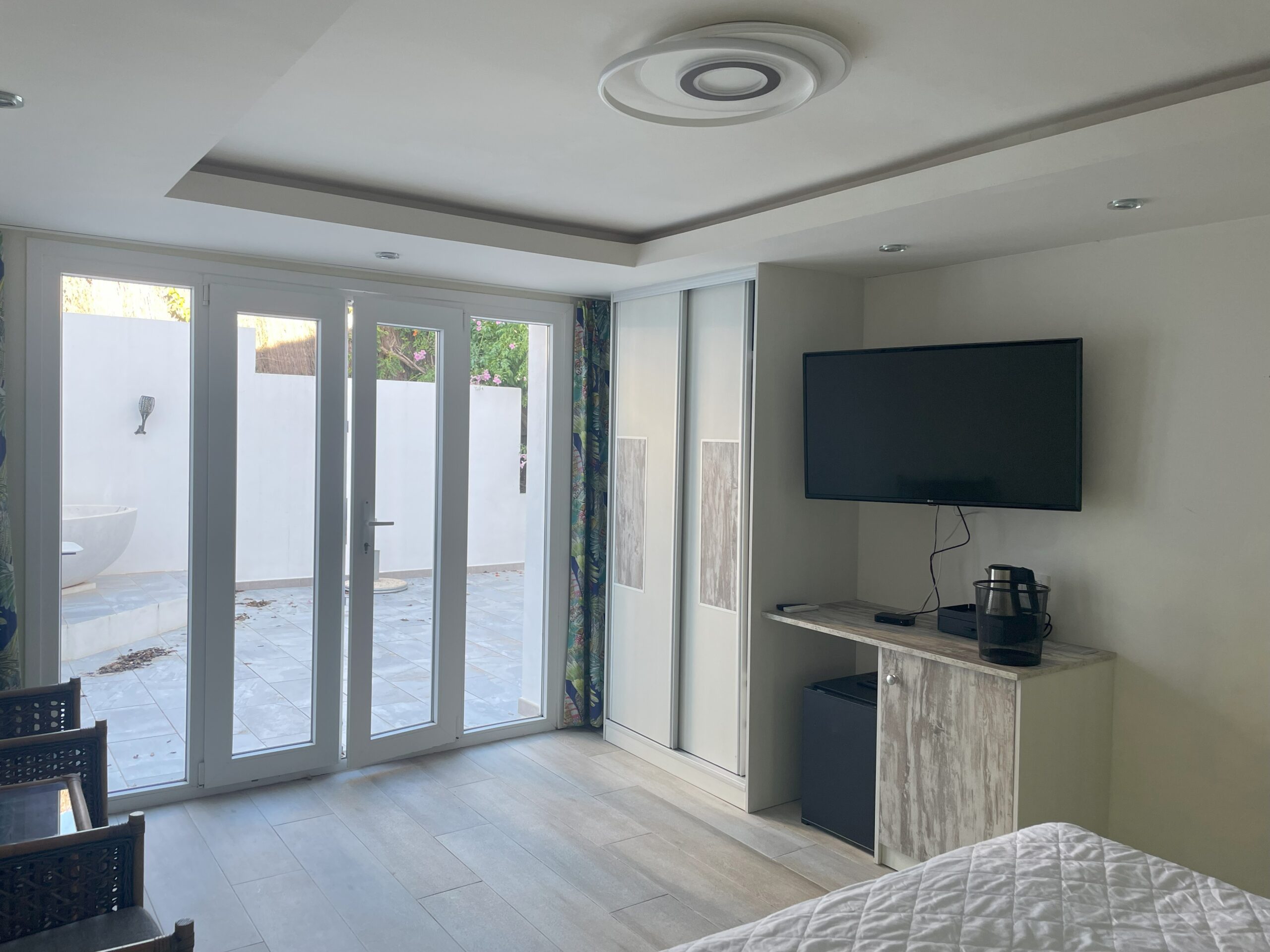 Suite existente con puertas acristaladas hacia la terraza, armario y televisión mural