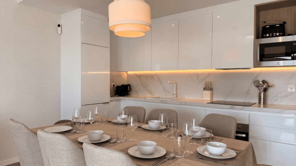 Cocina blanca y comedor preparados en un apartamento de Manilva