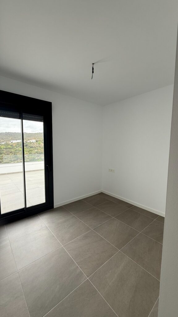 Habitación vacía con ventana antes del amueblamiento en Manilva