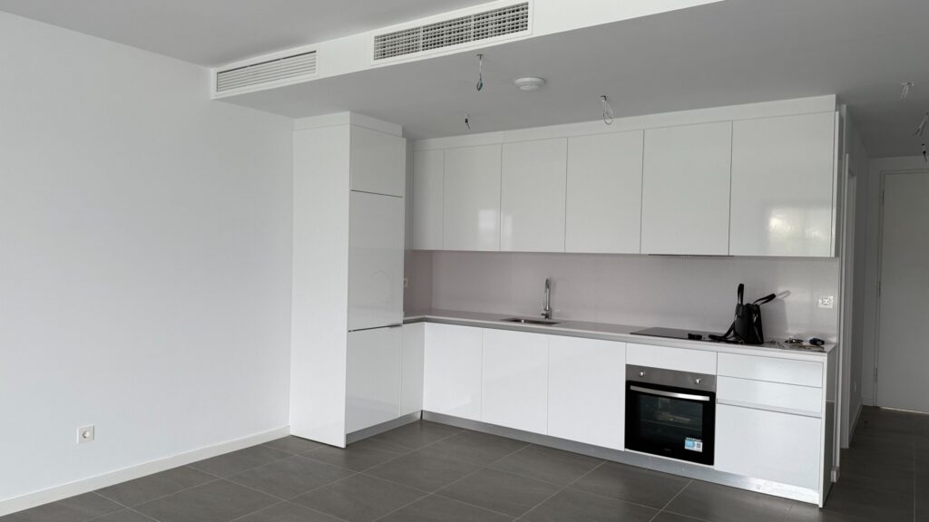 Salón vacío con cocina blanca instalada antes del amueblamiento en Manilva