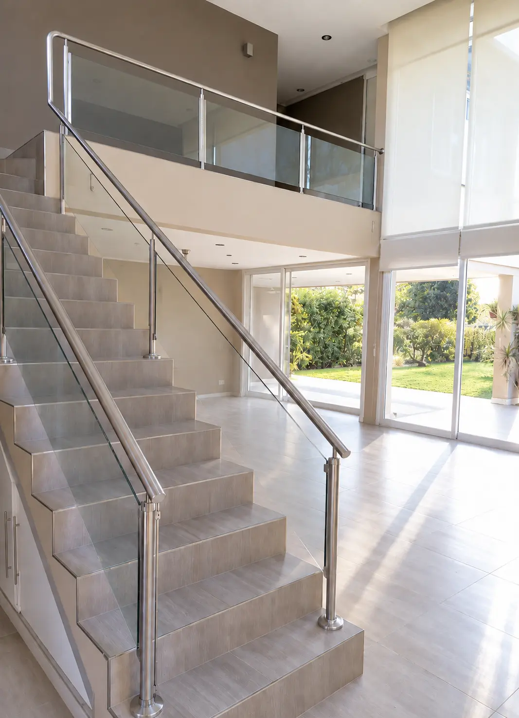 Diseño de vestíbulo de doble altura con escalera de vidrio y luz natural | Double-height entrance design with glass staircase and natural light