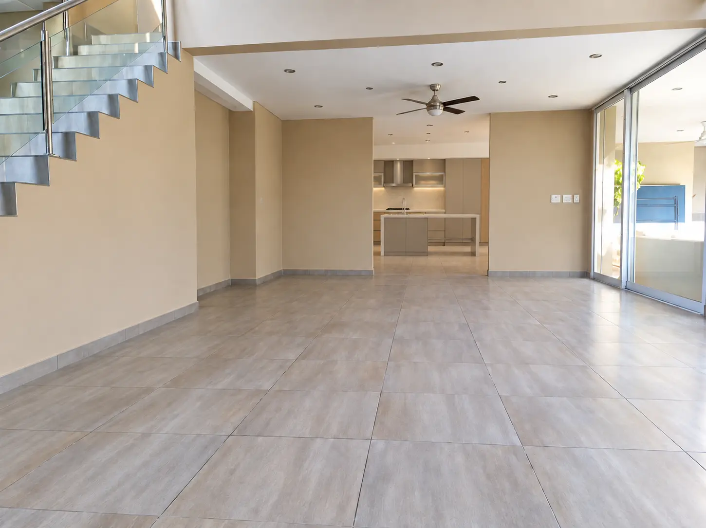 Diseño de salón abierto con cocina y escalera de vidrio | Open-plan living and kitchen design with glass staircase