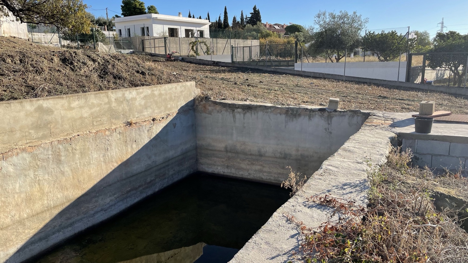Existing concrete basin and adjacent site conditions before the proposal.